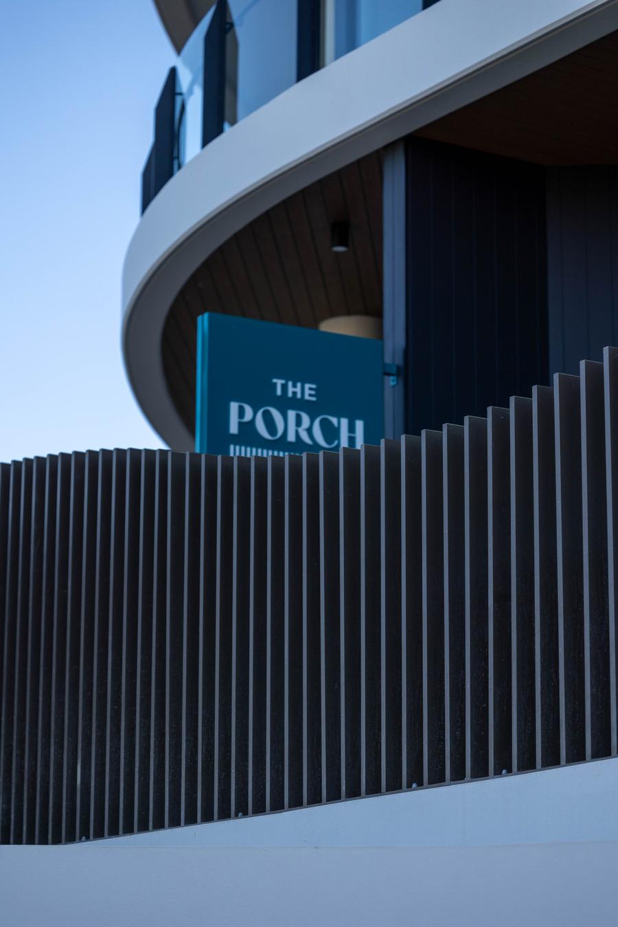 Curved vertical batten fence below a building sign