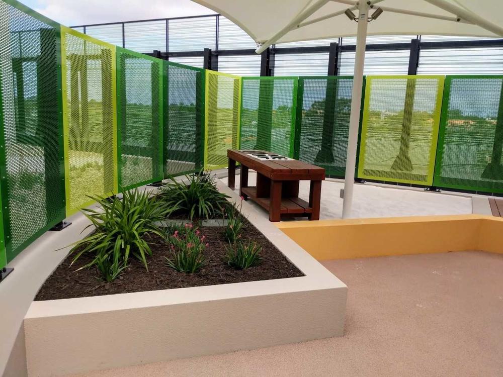 Colourful custom perforated screens in a school courtyard