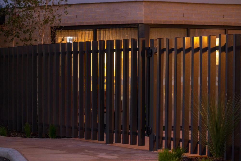 Dark vertical blade fencing lit at dusk