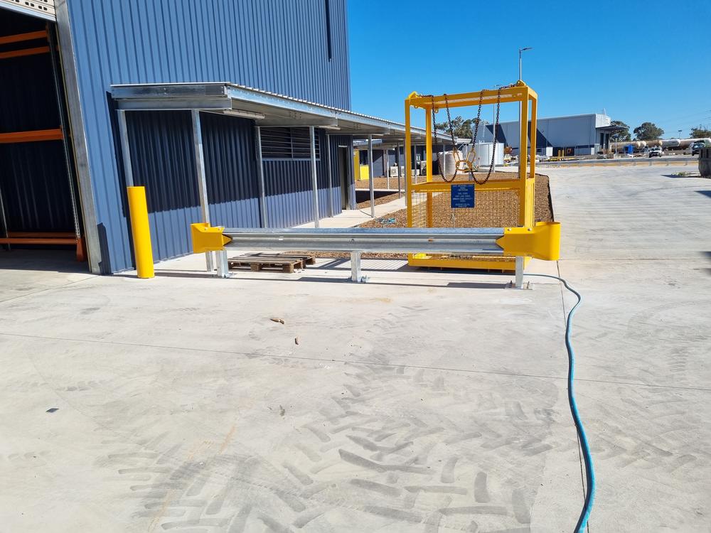 Yellow safety bollards and guard rail at a warehouse entry