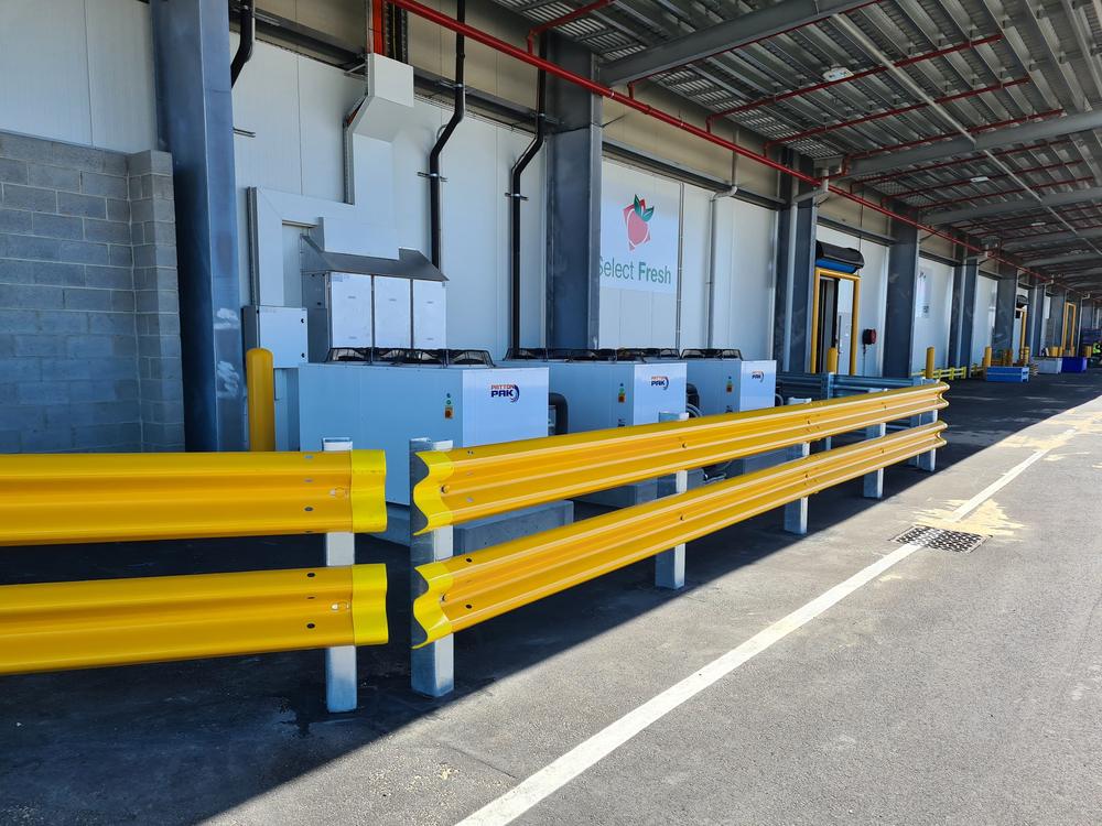 Yellow guard rail protecting plant along a warehouse loading area