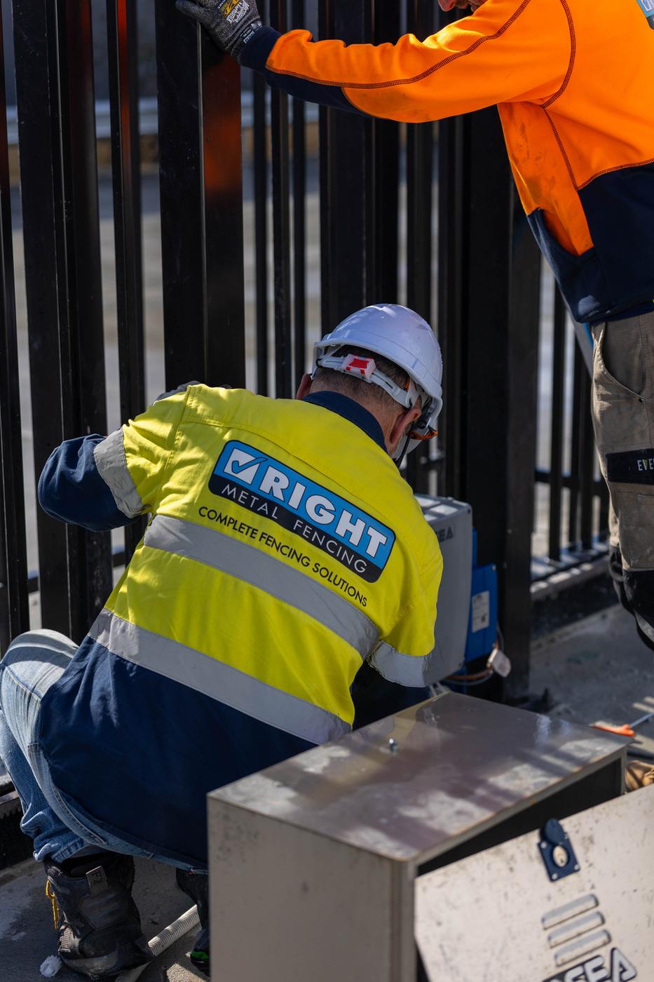 Technician fitting a gate motor